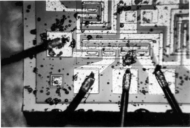 Photograph of particles on the surface of the die. (Photo courtesy Sandia Labs.)