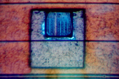 Photograph shows a 50 x 50 mm area of polyimide removed and a 20 x 20 mm area of metal 3 (aluminum) removed to expose metal 2 and metal 1 below. This was performed using about 50 shots from the 355 nm laser at low energy followed by two shots from the 532 nm laser at 50% power to open metal 3. (Courtesy New Wave Research).