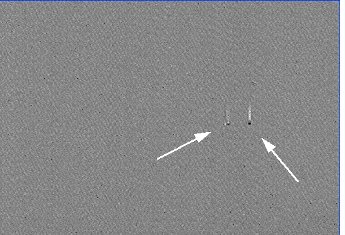 LIVA image of an entire die taken with a 633 nm, 5 mW HeNe laser. The LIVA signals from open-circuited junctions are highlighted by arrows. (Courtesy Sandia Labs).