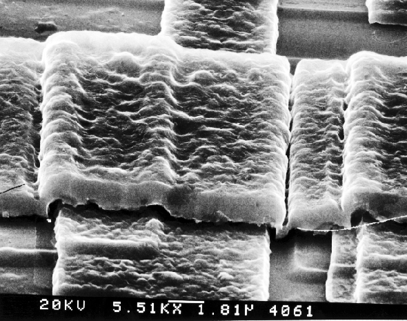 SEM image showing thinning at steps, poor step coverage. (Photo courtesy DM Data).