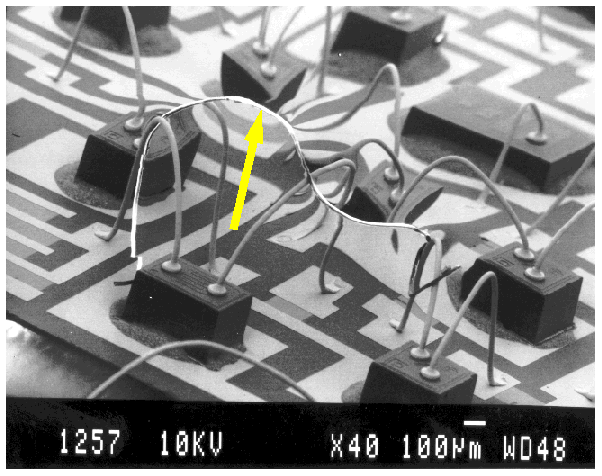 SEM image of magnetic particle bridging bond wires in a hybrid microcircuit. (Courtesy DM Data).