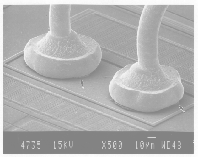 SEM image showing intermetallic growth on two bond wire/bond pad interfaces. (Courtesy Analytical Solutions).