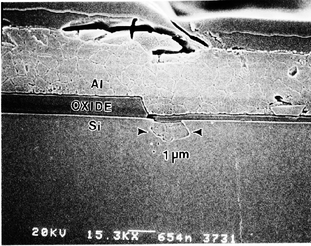 SEM image showing etching pit into the Si substrate as a result of a breach in the overlying oxide layer. (Courtesy Analytical Solutions).
