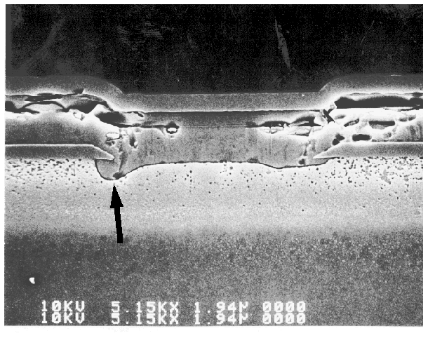 SEM image showing overetched contact windows that undercut the field oxide. (Courtesy Analytical Solutions).